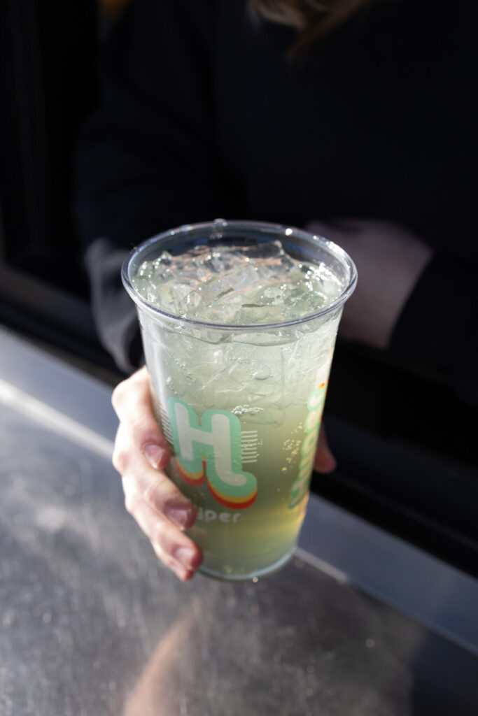 Customer holding a customized energy drink at a Hyper Energy Bar drive-thru