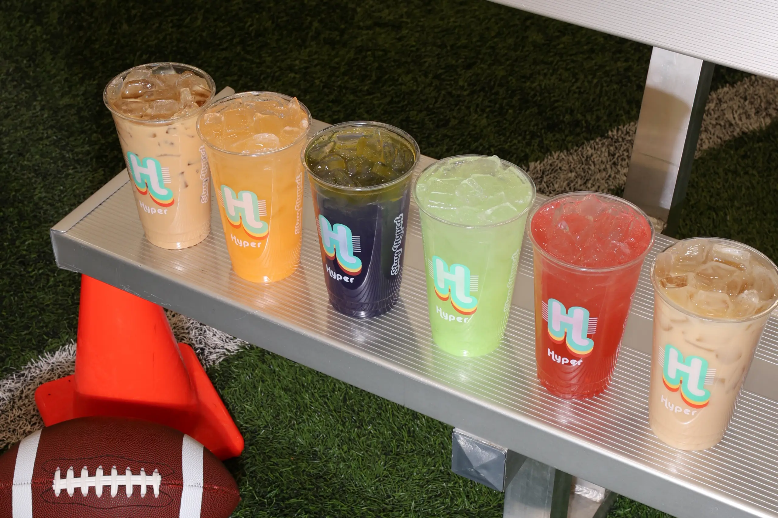 Hyper Huddle seasonal menu — six Hyper drinks on a football sideline bench